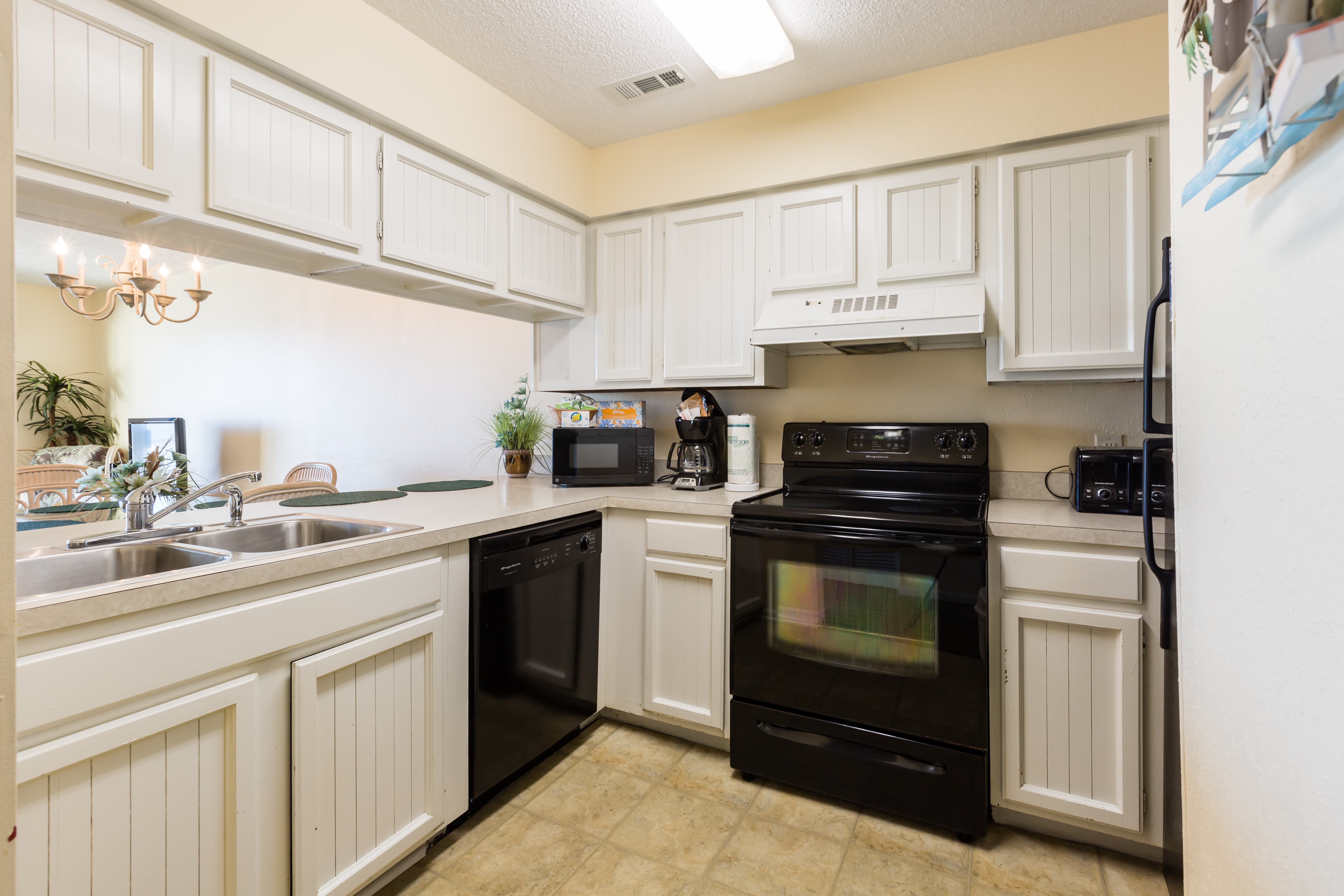A kitchen with white cabinets and black appliances